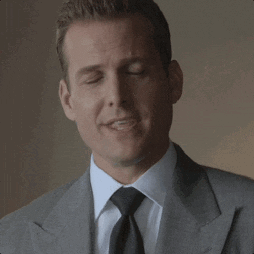 a man in a suit and tie looks at the camera