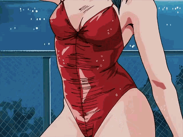a woman in a red swimsuit is standing in front of a fence