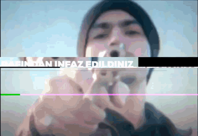 a man is pointing a gun at the camera with the words " barindan infaz edildiniz " in the background