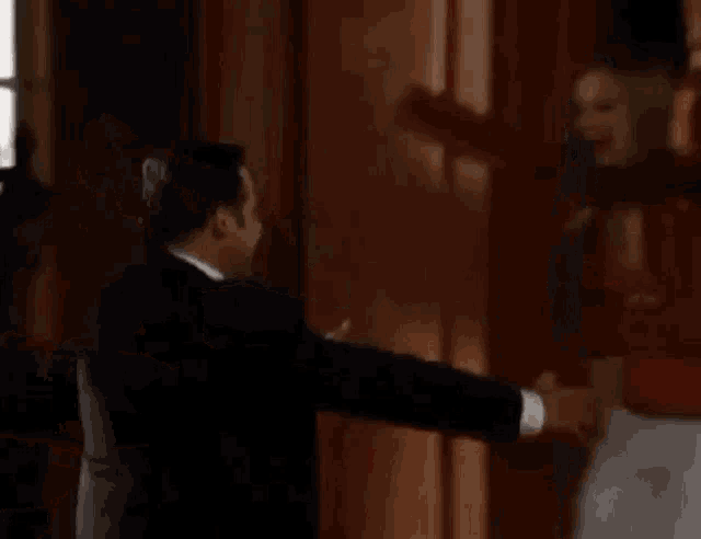 a man in a suit is holding a woman in his arms .
