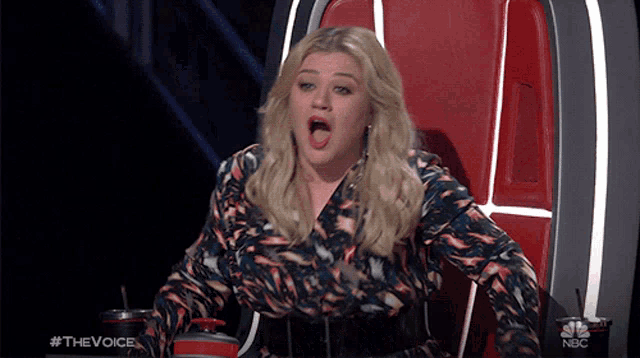 a woman is sitting in a chair with her mouth open and a nbc logo in the corner