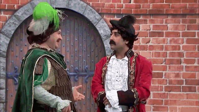 two men dressed in costumes are standing next to each other
