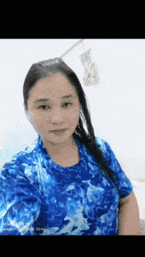 a woman is wearing a blue shirt and taking a selfie .