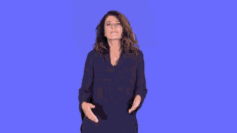 a woman in a blue shirt is shrugging her shoulders against a blue background