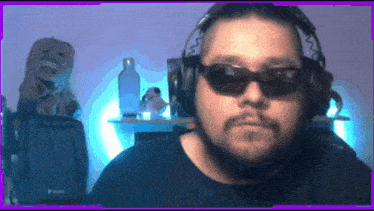 a man wearing sunglasses and headphones is looking at the camera