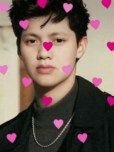 a young man with pink hearts around his face and neck