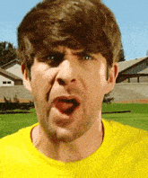 a man in a yellow shirt making a funny face