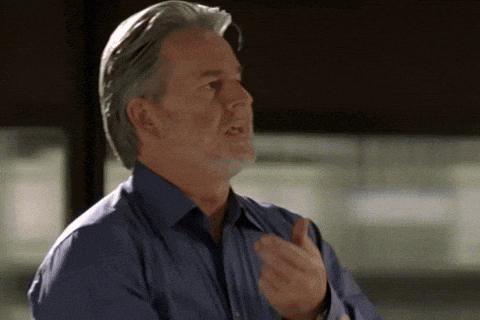 a man with gray hair and a blue shirt is talking