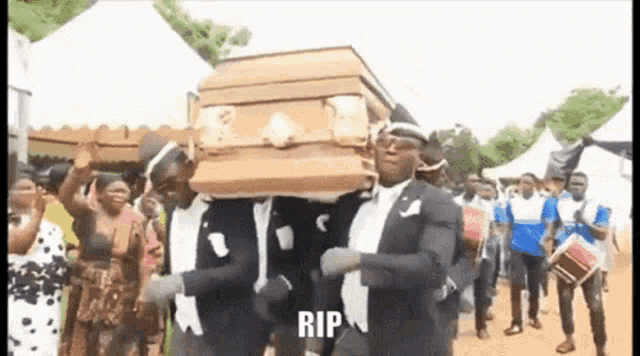 a group of men are carrying a coffin in a funeral procession .