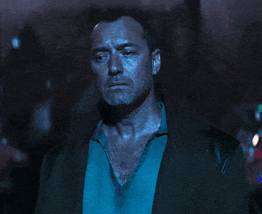 a man with a beard is wearing a trench coat