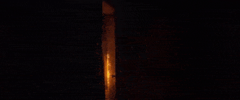 a fire is coming out of a doorway at night .