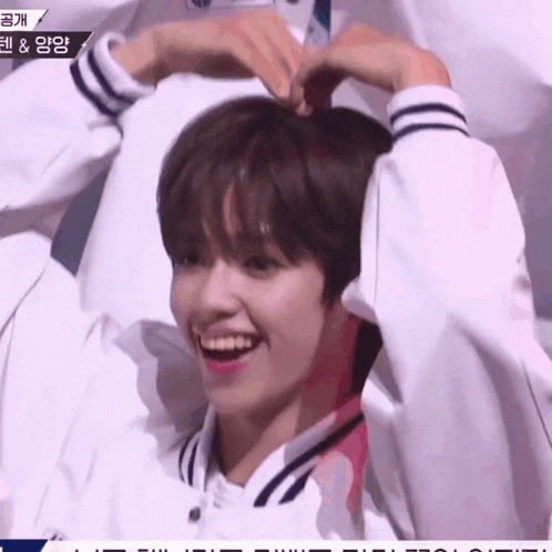 a man making a heart with his hands on his head