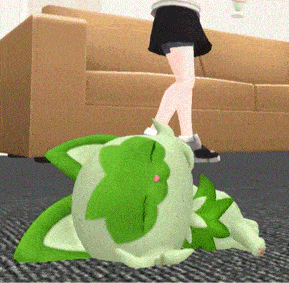 a green stuffed animal laying on the floor next to a couch