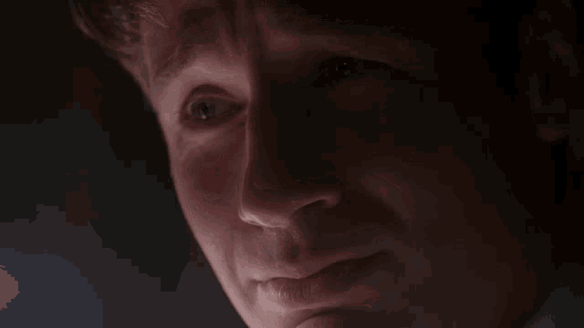 a close up of a man 's face with the words " she is sad " above him