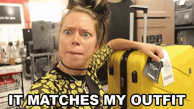 a woman is standing next to a yellow suitcase that says " it matches my outfit " on it