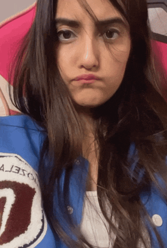 a woman wearing a blue jacket with the letter u on it