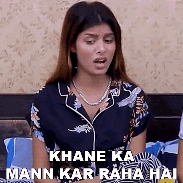 a woman sitting on a bed with the words khane ka mann kar raha hai above her