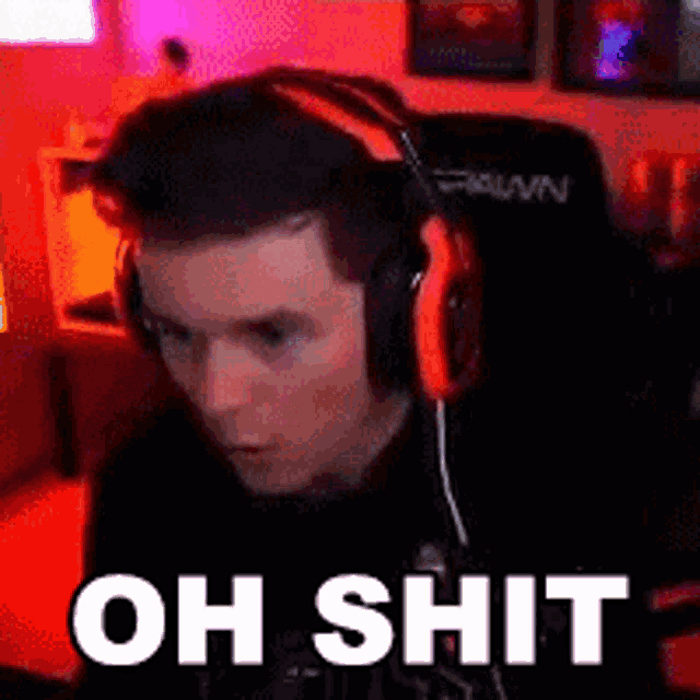 a man wearing headphones is sitting in a chair and making a funny face .