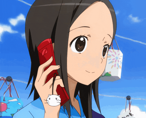 a girl is talking on a red cell phone