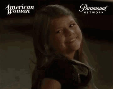 a girl is smiling in front of a paramount network ad