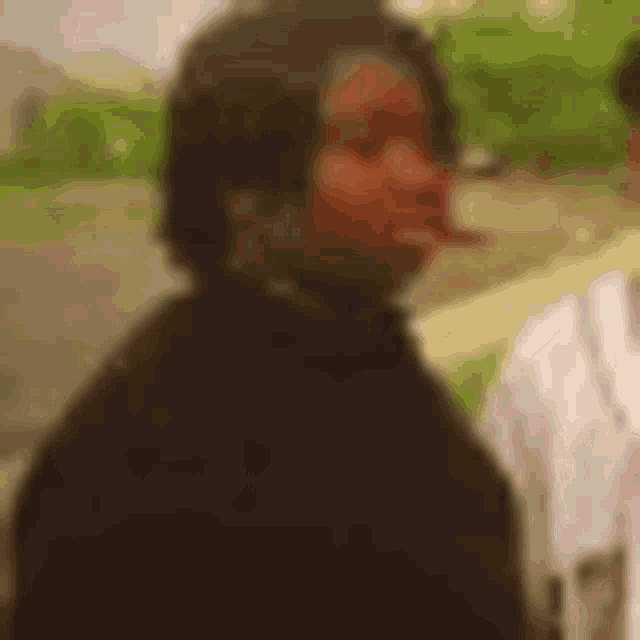 a blurry picture of a woman in a black turtleneck sweater smoking a cigarette .
