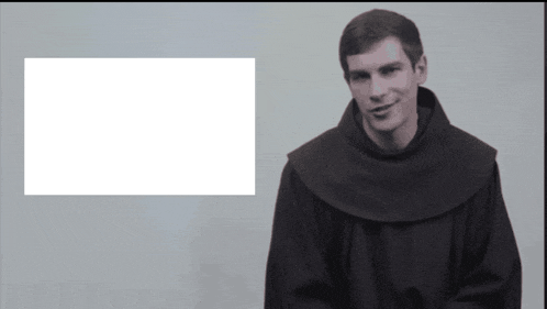 a man in a robe stands in front of a white box