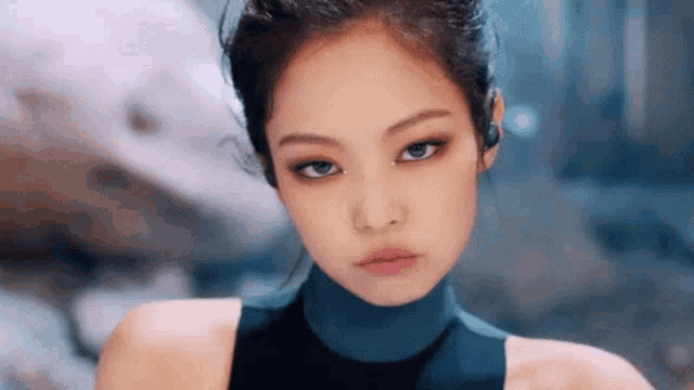a close up of a woman 's face with a ponytail looking at the camera .