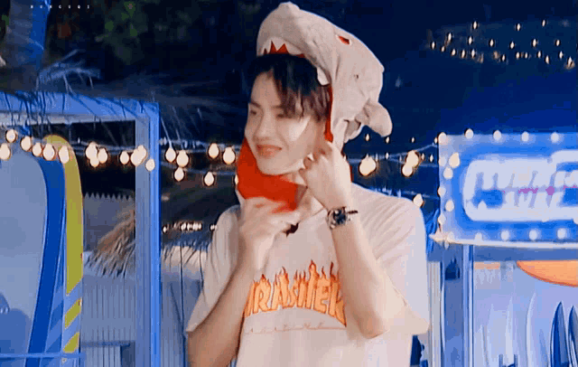 a man wearing a shark headband and a thrasher shirt