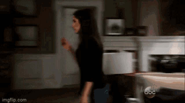 a blurry picture of a woman in a living room with abc written on the bottom right