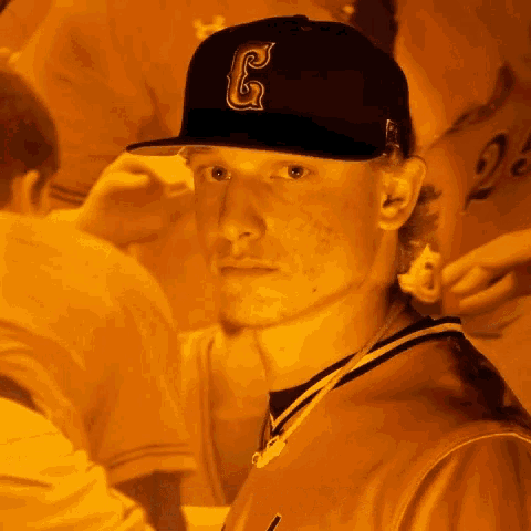 a man wearing a black hat with a letter g on it