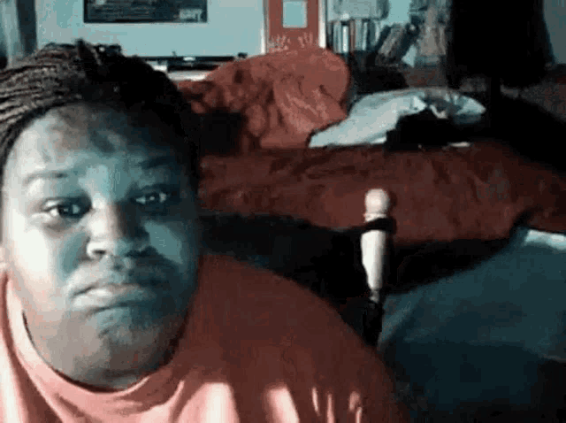 a woman is sitting in a chair in front of a bed .