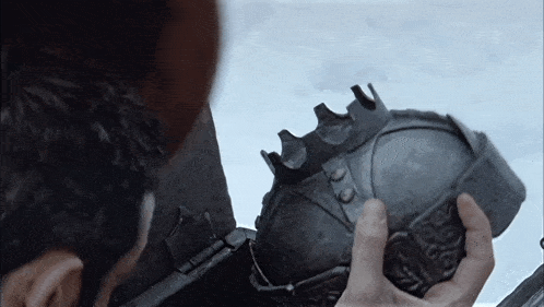 a man is holding a helmet with a crown on top of it