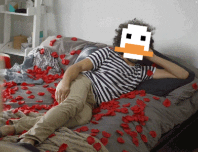 a man is laying on a bed with a pixelated duck face on his face