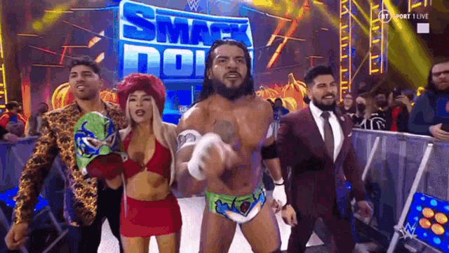 a group of wrestlers are standing on a stage in front of a sign that says smackdown .