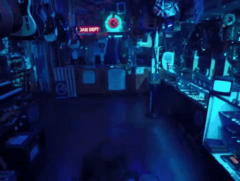 a man with a beard is standing in a store with a blue light shining on him .