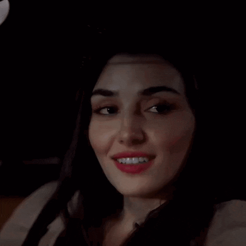 a close up of a woman smiling in the dark