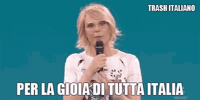 a woman is holding a microphone in front of a blue background and says per la gioia di tutta italia