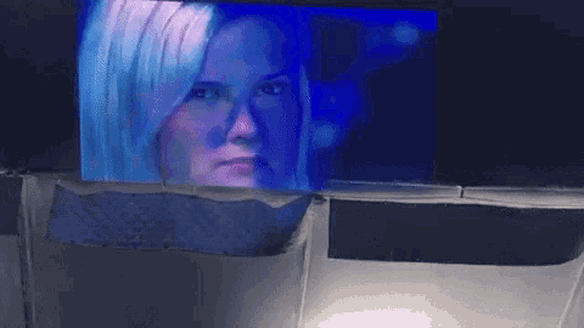 a woman 's face is displayed on a large screen