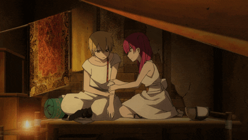 a man and a woman are sitting next to each other and the woman is touching the man 's wrist
