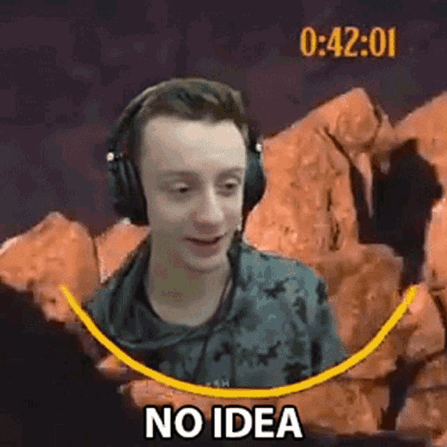 a young man wearing headphones is sitting in front of a rock wall and says `` no idea '' .