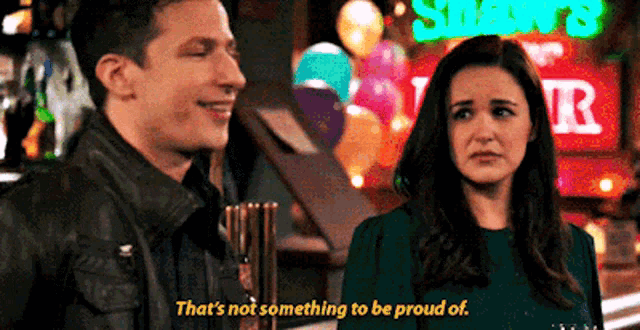 a man and a woman are standing next to each other in front of a bar .