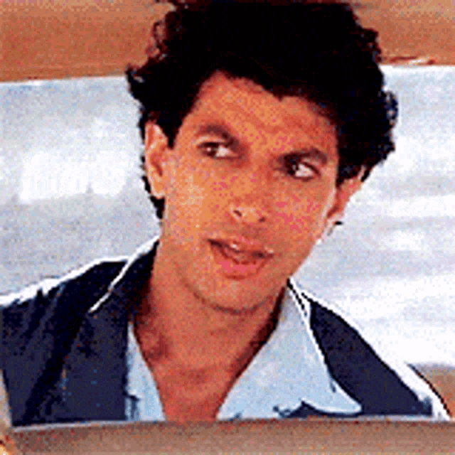 a man is looking out of a car window and making a funny face .