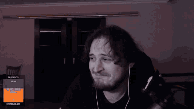 a man with a beard is smiling in front of a screen that says vladislava