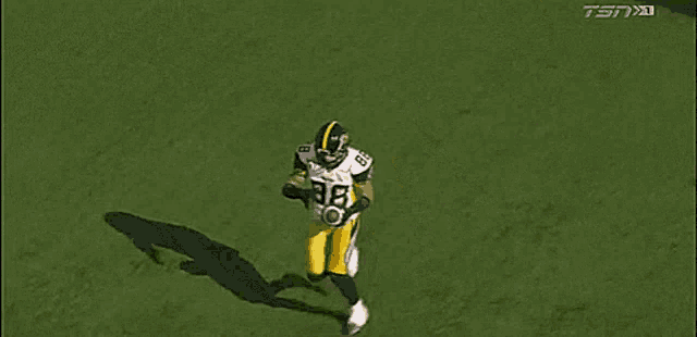 three football players are running on the field .