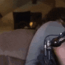 a man is sitting on a couch with a microphone .