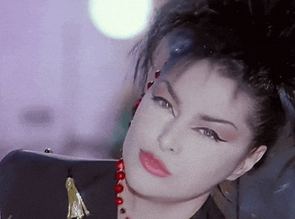 a close up of a woman 's face with a necklace of red beads