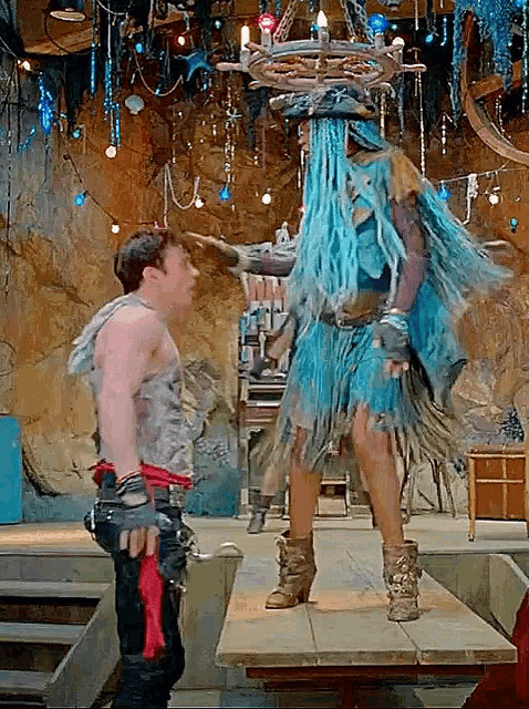 a man standing next to a woman wearing a blue dress