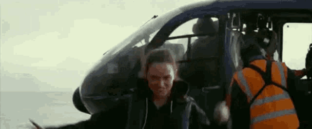 a woman is getting out of a helicopter .
