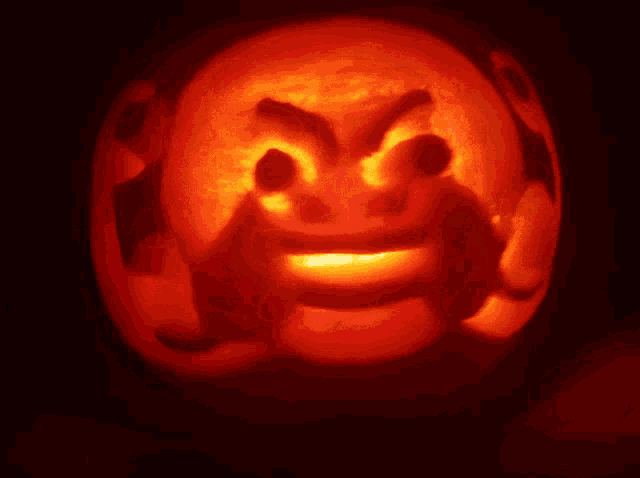 a pumpkin with a face carved into it is lit up