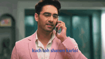 a man in a pink jacket is talking on a cell phone .